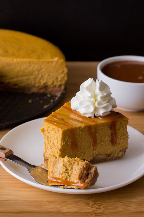 Smooth & creamy Pumpkin Cheesecake with a cinnamon graham cracker crust, delicious spices, the perfect pumpkin flavor & drizzled with salted caramel sauce. With lots of baking tips included - try this perfect recipe for fall!