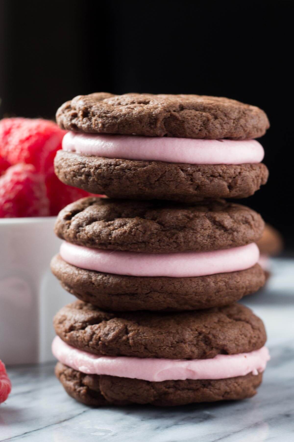 Creamy raspberry frosting sandwiched between two soft & fudgy chocolate cookies. These sandwich cookies are the perfect recipe for Valentine's!