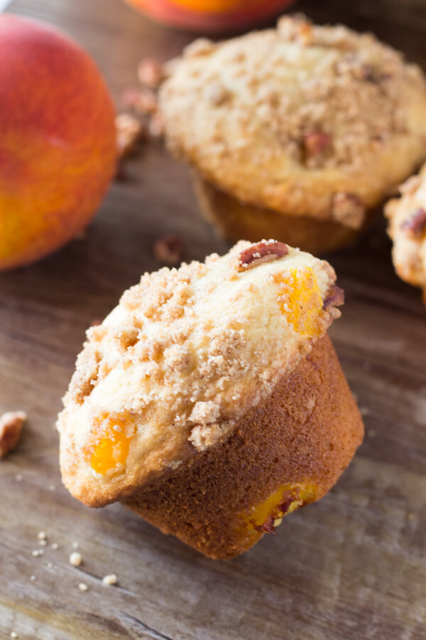 Fluffy, buttery, super soft Peach Muffins with Streusel Topping - The combo of fresh summer peaches and crunchy, cinnamon, pecan streusel makes these the perfect peach muffins!