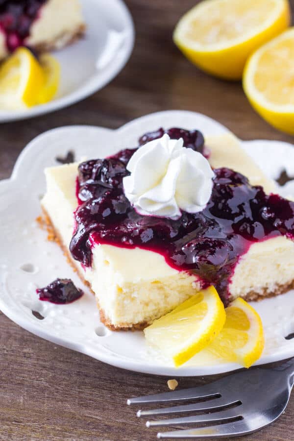 Lemon Blueberry Cheesecake Squares. Smooth & creamy lemon cheesecake with a graham cracker crust and blueberry sauce. Perfect for spring! www.justsotasty.com