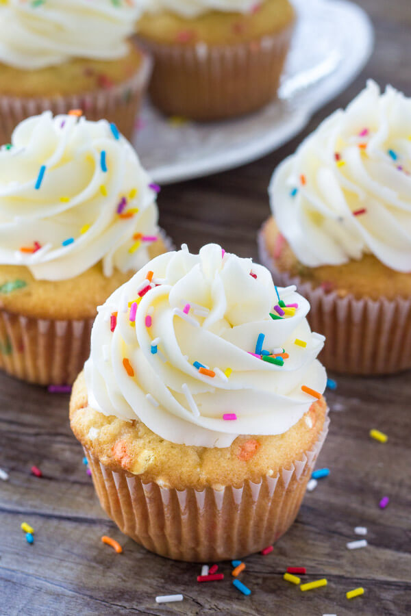 Three funfetti cupcakes from scratch topped with vanilla frosting and sprinkles. 