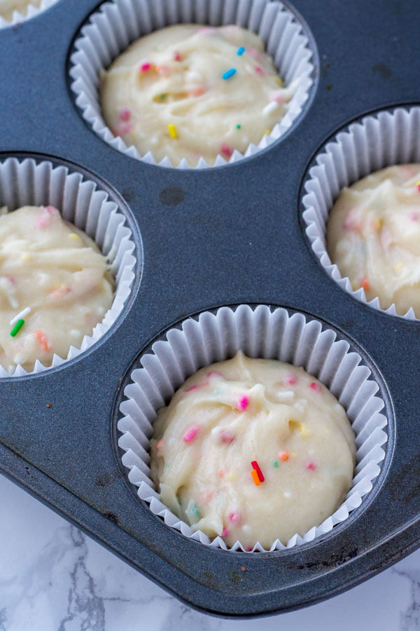 Funfetti cupcake batter spooned into the muffin pan and ready to bake. 