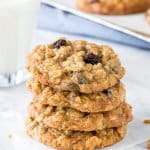 A stack of oatmeal raisin cookies with a glass of milk