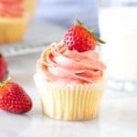 Vanilla cupcake with strawberry frosting and a glass of milk