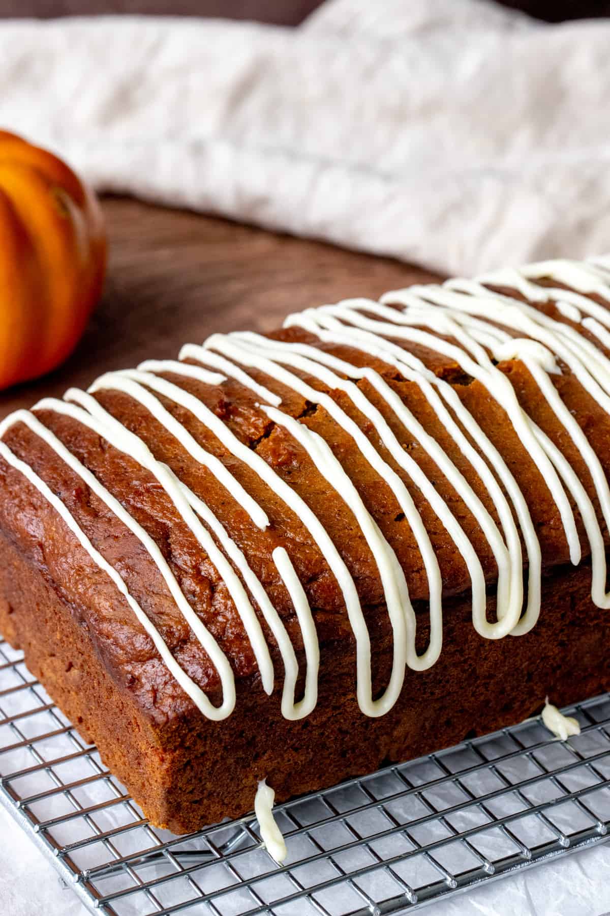 Loaf of pumpkin bread drizzled with cream cheese glaze