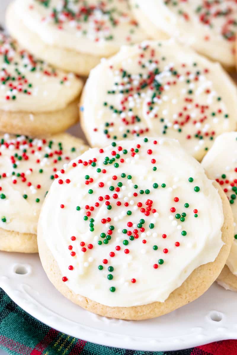 Plate of thick, soft, sour cream sugar cookies with frosting and sprinkles