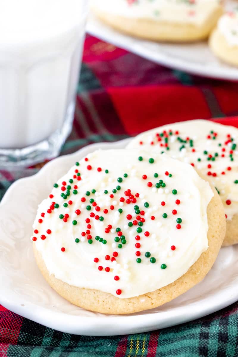 2 Christmas sugar cookies with a glass of milk