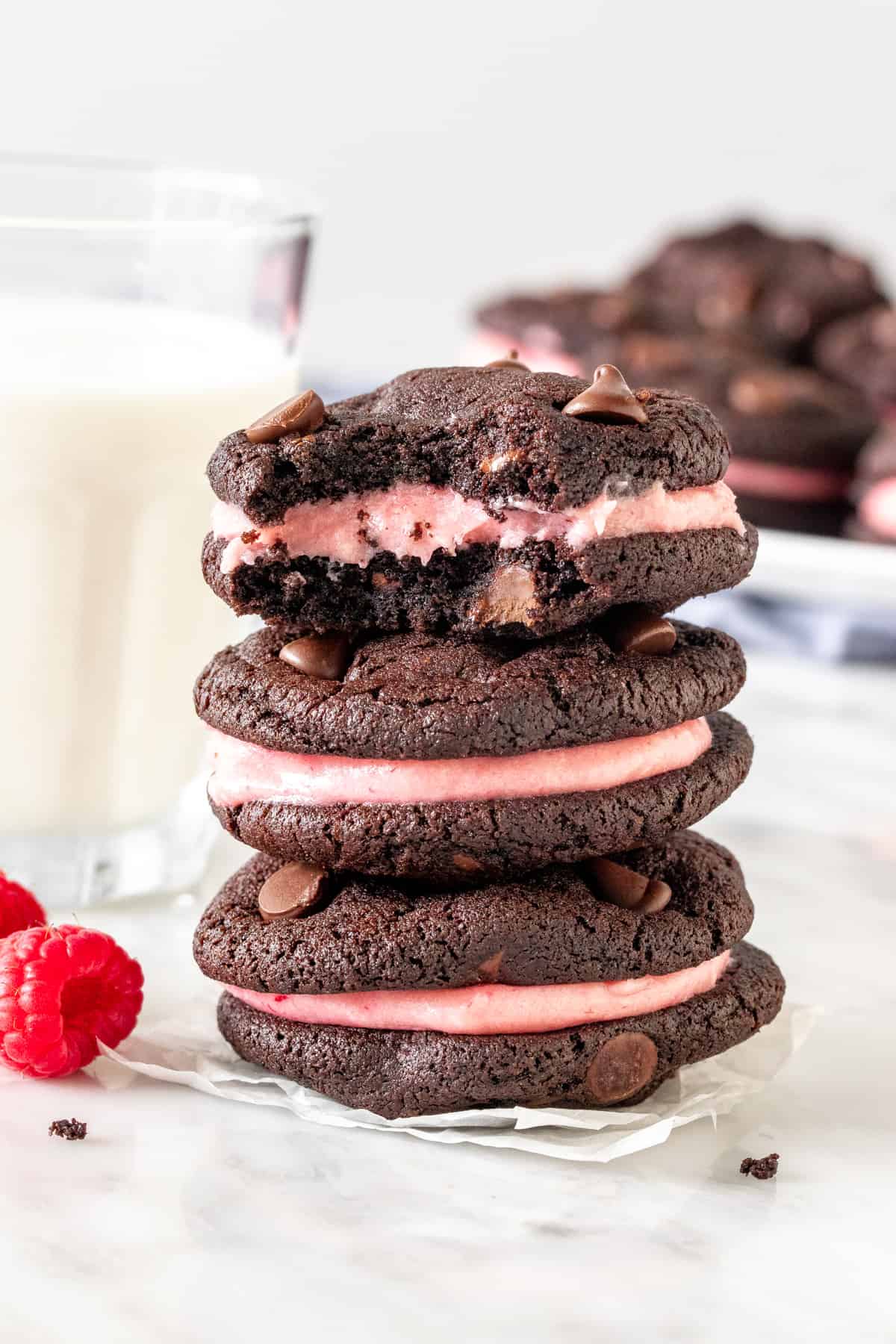 Stack of 3 chocolate cookies with raspberry frosting.