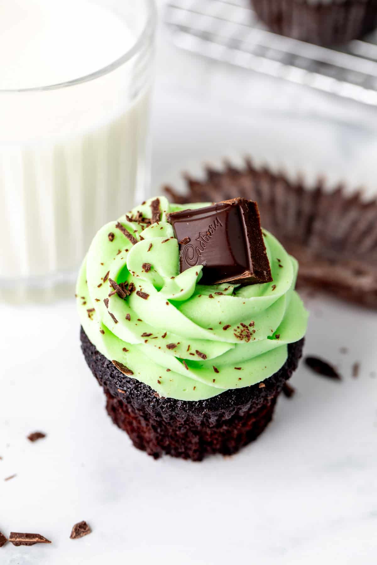 Mint chocolate cupcake with green mint frosting with a glass of milk