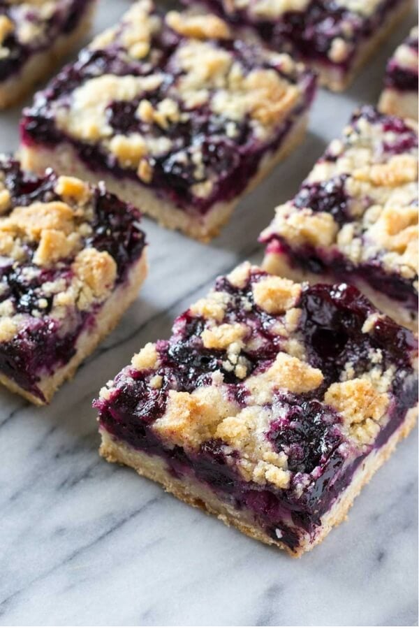Side angle shot of 6 blueberry crumble bars arranged in 2 rows.