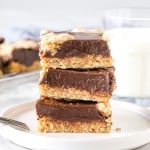 Stack of 3 oatmeal fudge bars on a plate with a glass of milk.