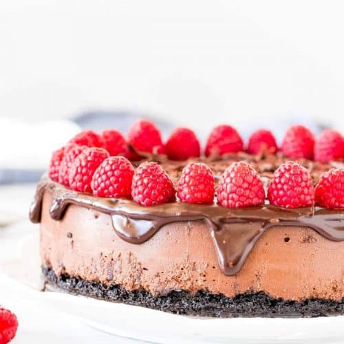 Chocolate cheesecake with chocolate ganache and raspberries on top.