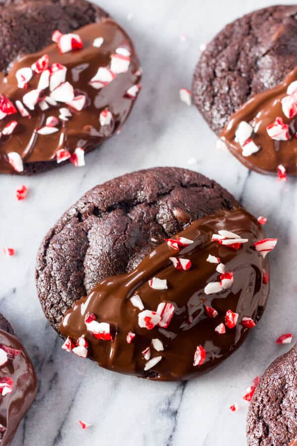 Peppermint Double Chocolate Cookies. Super fudgy double chocolate cookies that are infused with peppermint, dipped in chocolate and sprinkled with candy canes. The perfect Christmas cookie. www.justsotsty.com