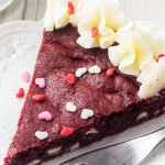 This Red Velvet Cookie Cake is soft & chewy, filled with white chocolate chips & decorated with cream cheese frosting. The ULTIMATE Red Velvet dessert #valentines #redvelvet #cookiecake #cookie #dessert #recipes