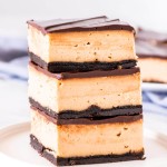 Stack of 3 peanut butter cheesecake bars with Oreo crust and chocolate topping.