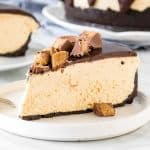Slice of no-bake peanut butter cheesecake with peanut butter cups on top.