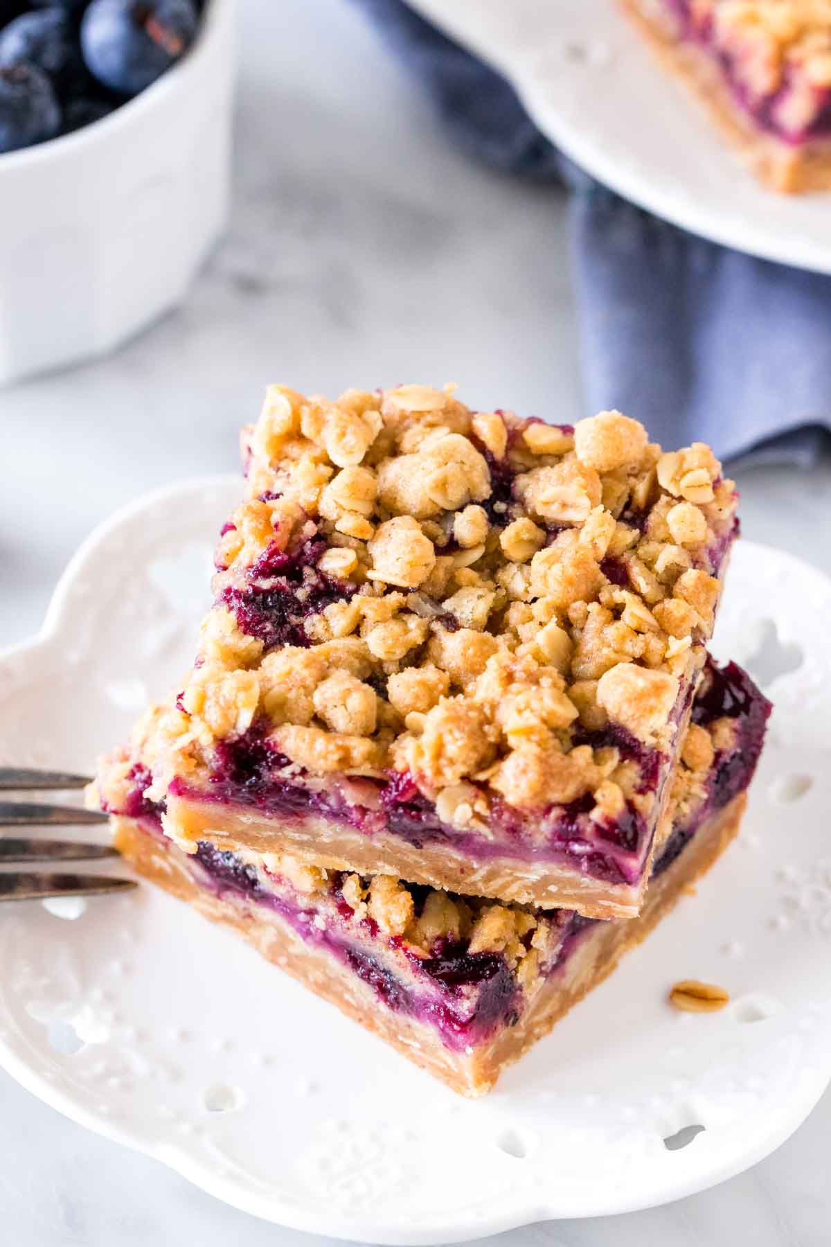 2 blueberry bars stacked on top of each other on a plate. 