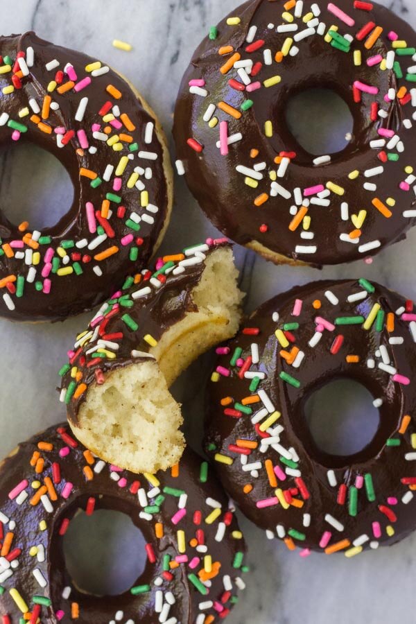 These baked vanilla doughnuts with chocolate glaze have a delicious cake doughnut texture and are ultra-moist. With a thick chocolate glaze and coated in sprinkles, they won't last long.... Plus, there's no hot oil or deep frying!
