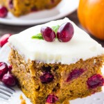 Slice of Cranberry Pumpkin Cake with Cream Cheese Frosting with a bite taken out of it and a fork resting on the side of the plate.