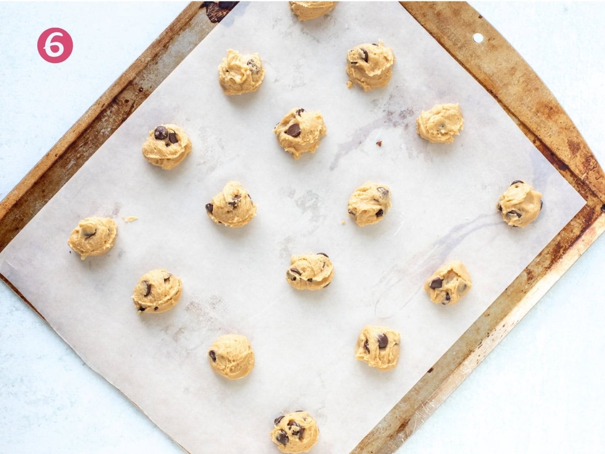 Lined cookie sheet with unbaked mini cookie dough balls