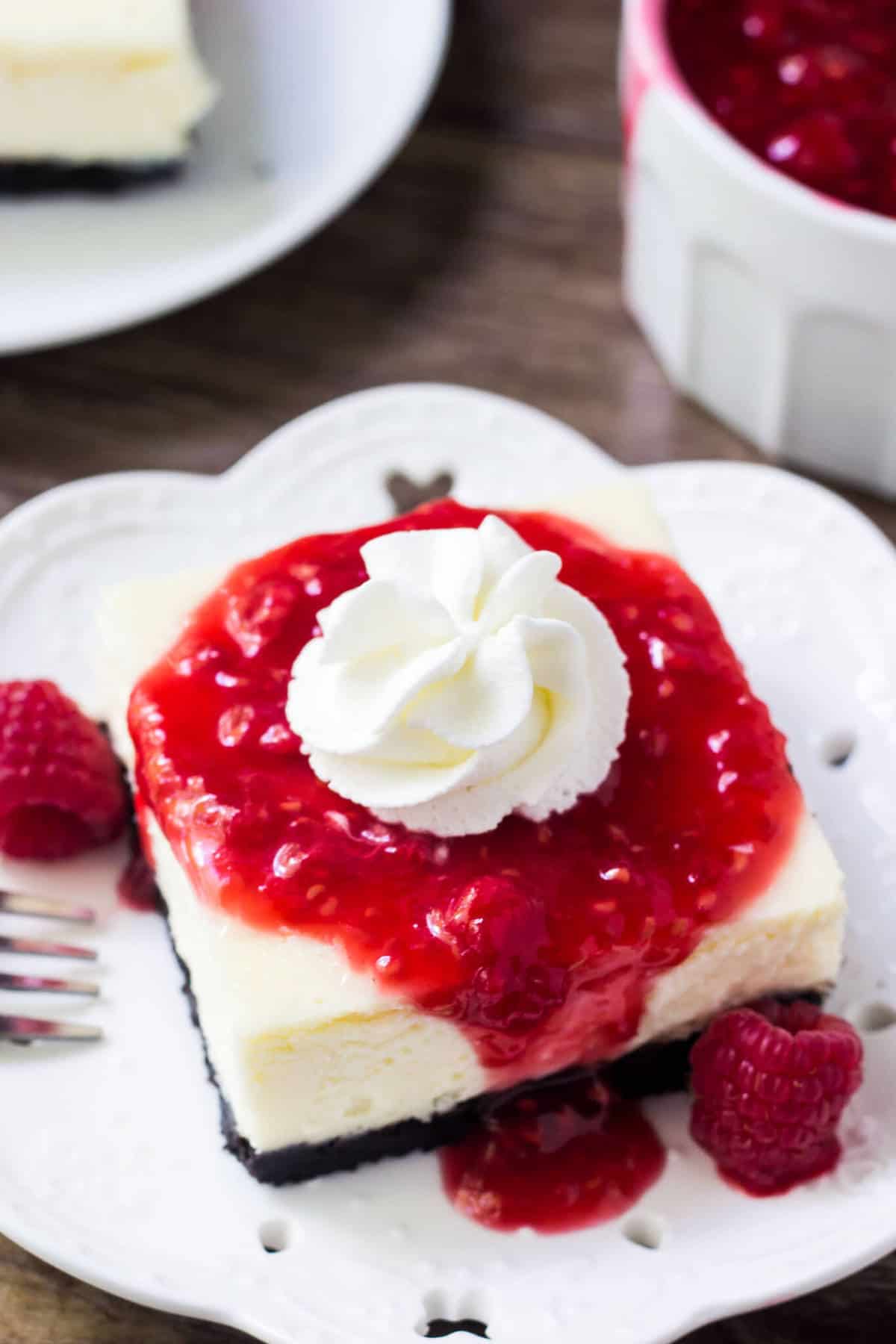 The absolute BEST white chocolate cheesecake bars with raspberry sauce. So creamy, not too sweet and with a delicious Oreo crust. 