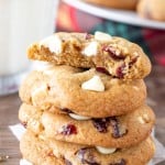 Stack of white chocolate cranberry cookies with the top cookie broken in half.