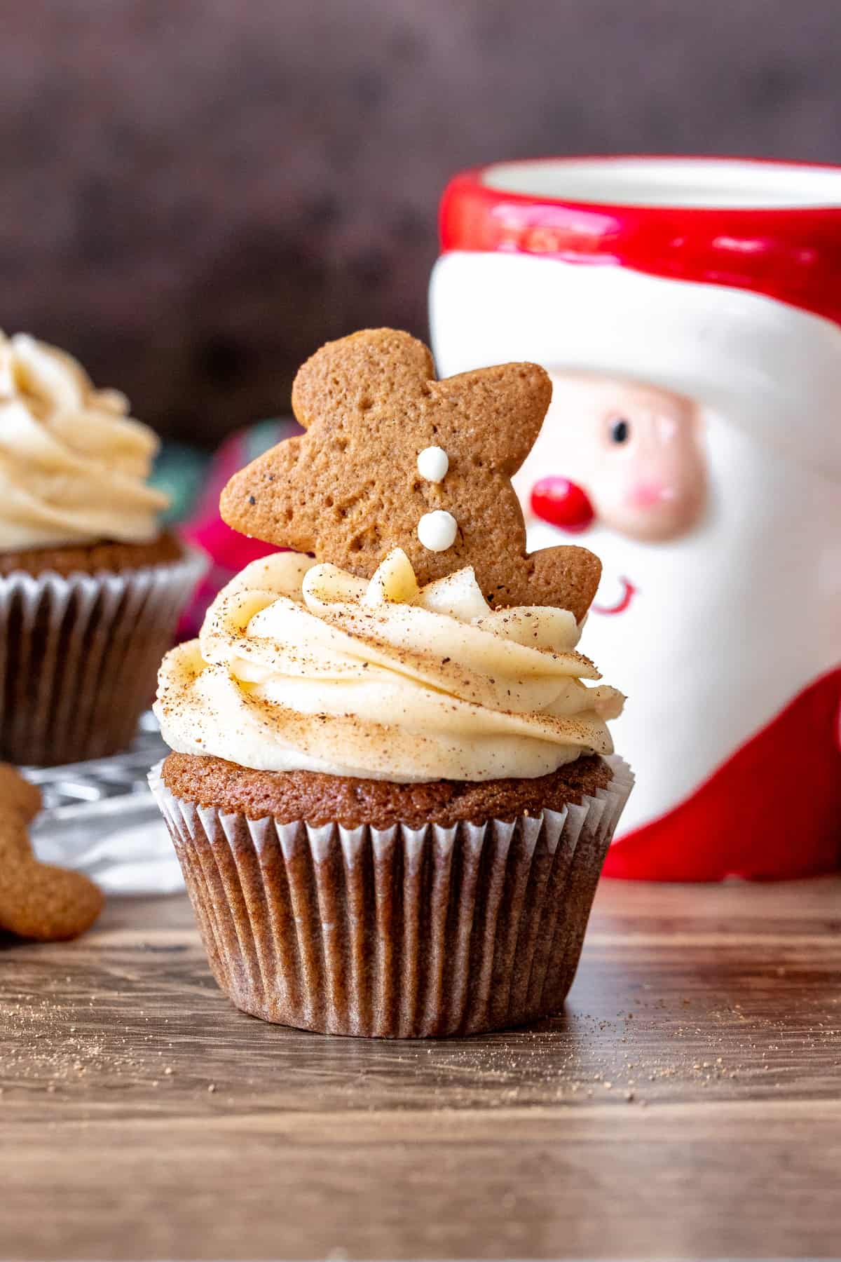 Gingerbread cupcake decorated with cinnamon cream cheese frosting with a Santa mug