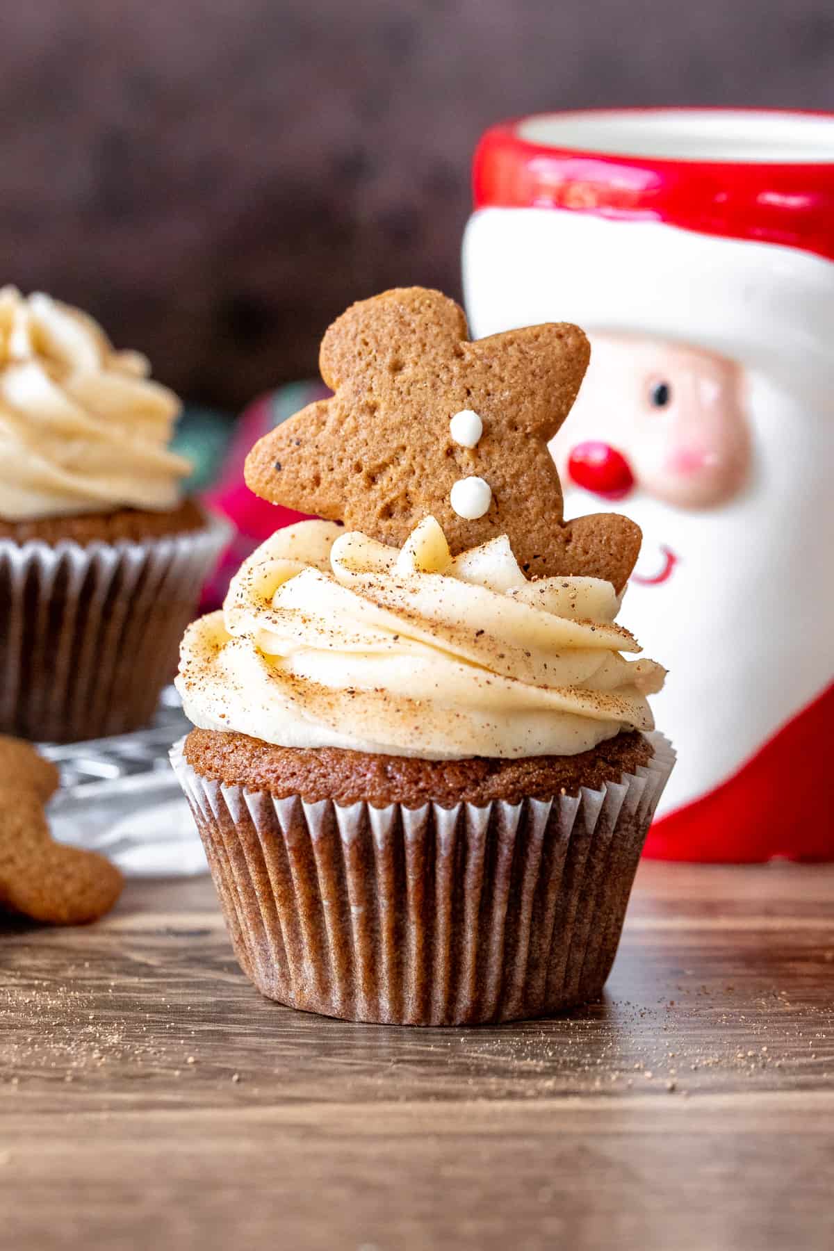 Gingerbread cupcake with cream cheese frosting and mini gingerbread man cookie on top. 