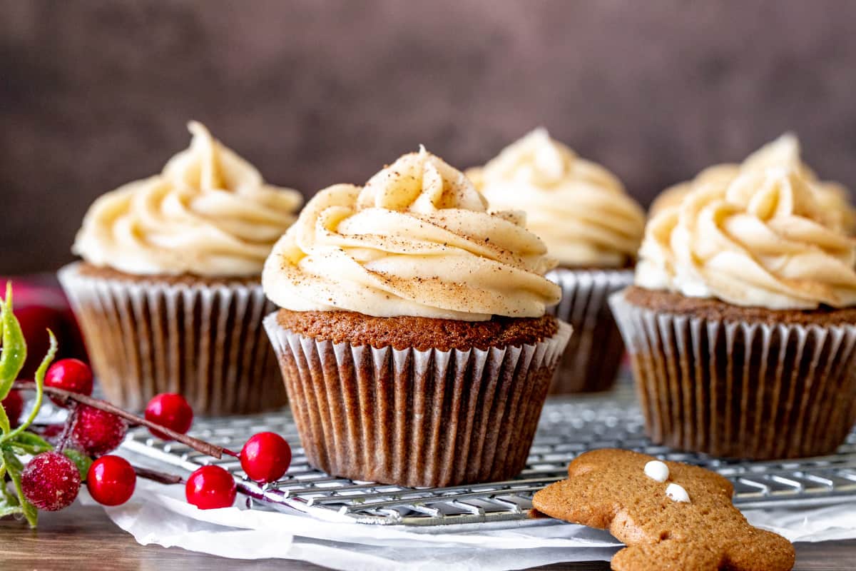 Gingerbread cupcakes topped with cinnamon cream cheese frosting on cooling rack