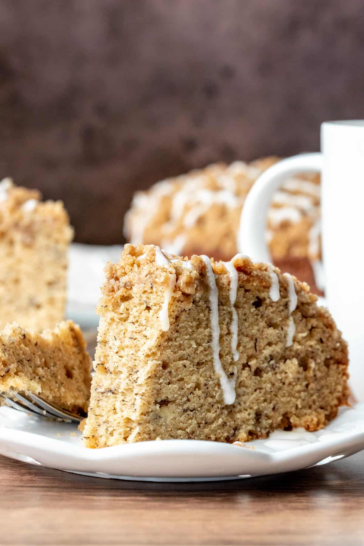 Slice of banana cake with streusel topping with bite taken out
