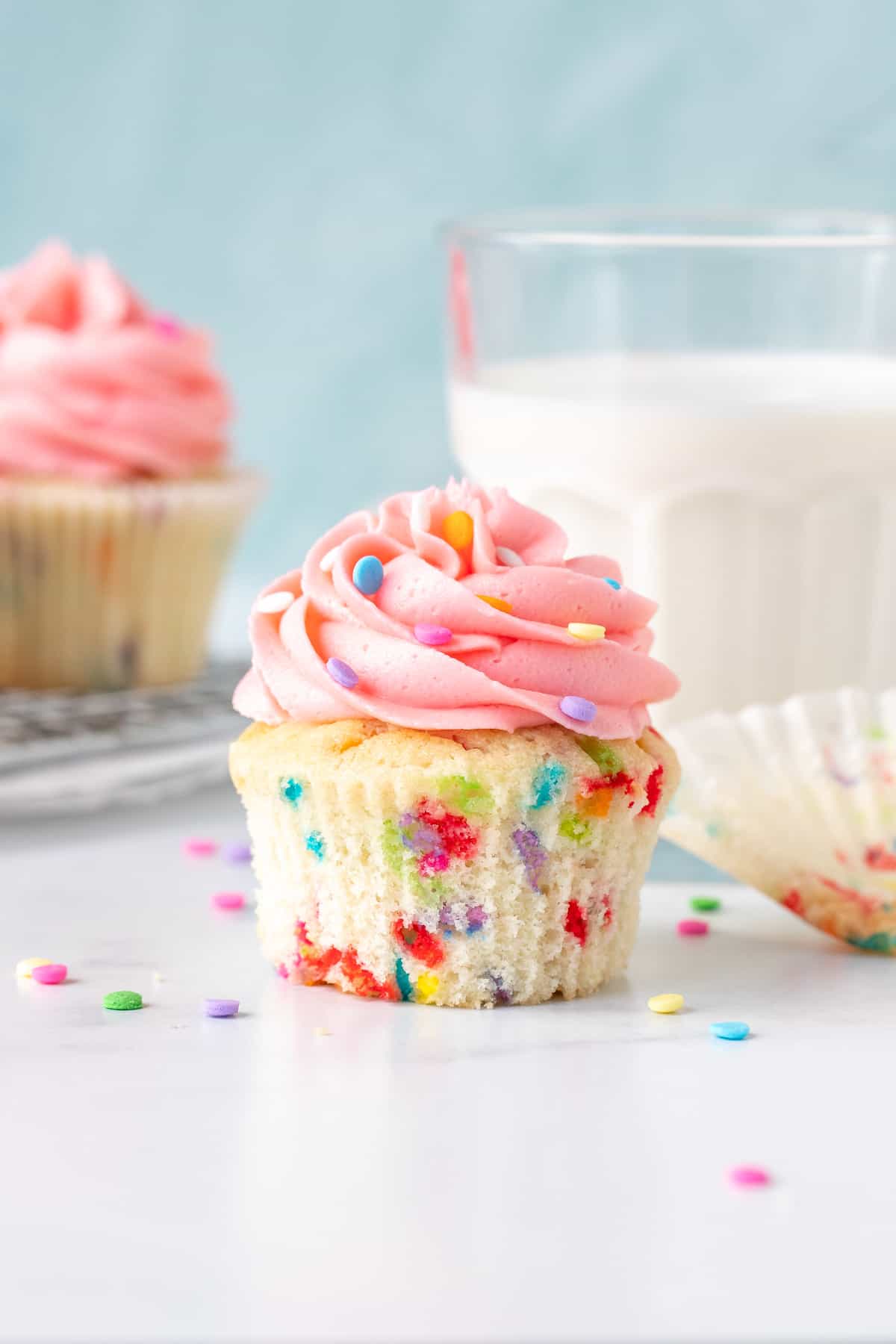 Sprinkle cupcake with vanilla frosting with paper removed