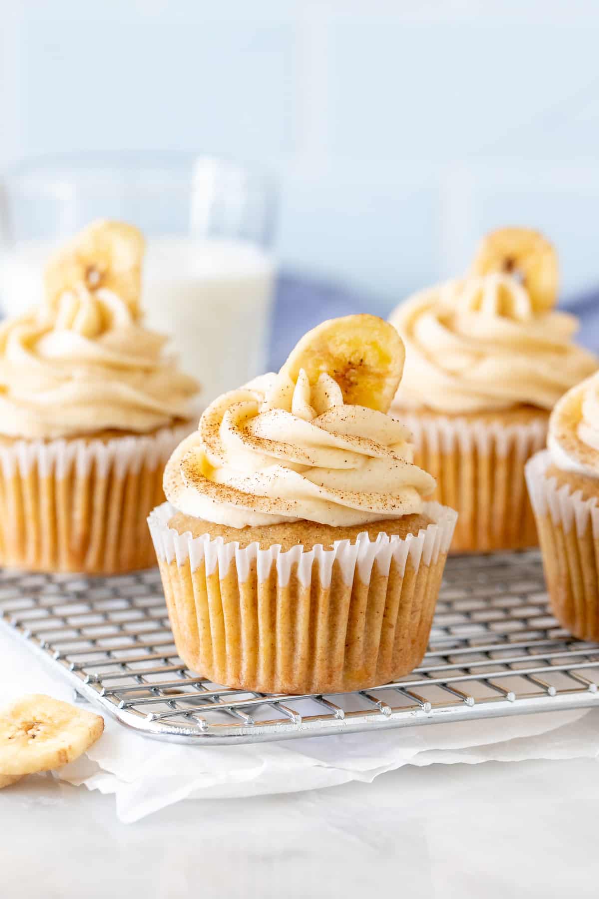 Banana cupcakes with cream cheese frosting on a cooling rack