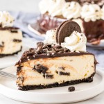 Slice of Oreo cheesecake with chocolate ganache and crushed Oreos on top.
