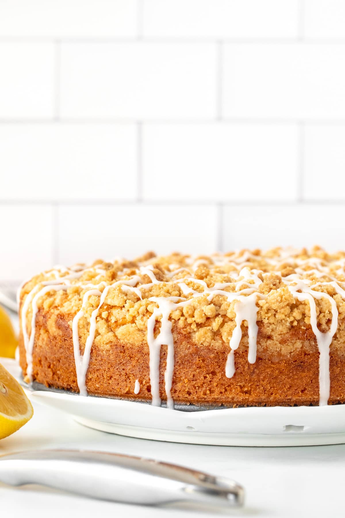 9-inch round lemon coffee cake with streusel topping drizzled with glaze