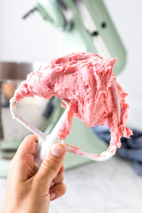 Stand mixer paddle attachment with raspberry buttercream frosting.