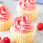 3 vanilla cupcakes with raspberry frosting.