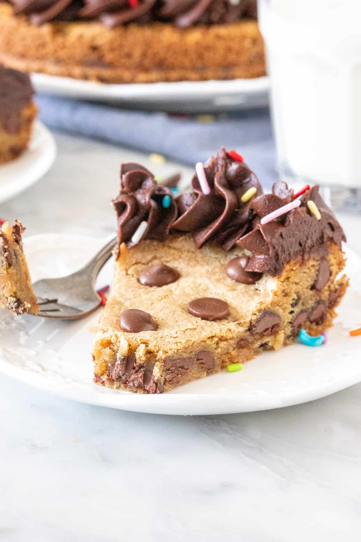 Slice of chocolate chip cookie cake with a bite taken out.