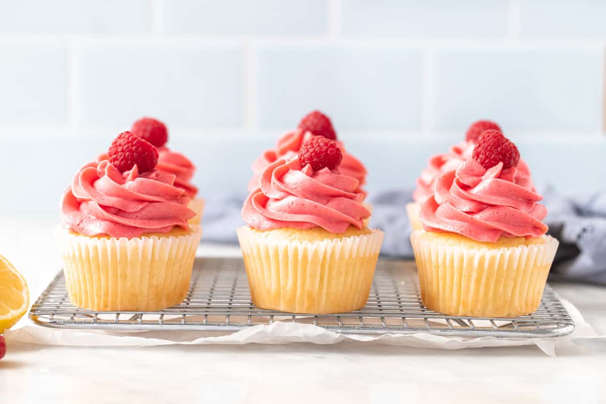 6 lemon raspberry cupcakes each with a raspberry on top