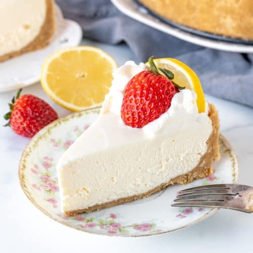 Piece of no-bake lemon cheesecake with graham crust and strawberry on top