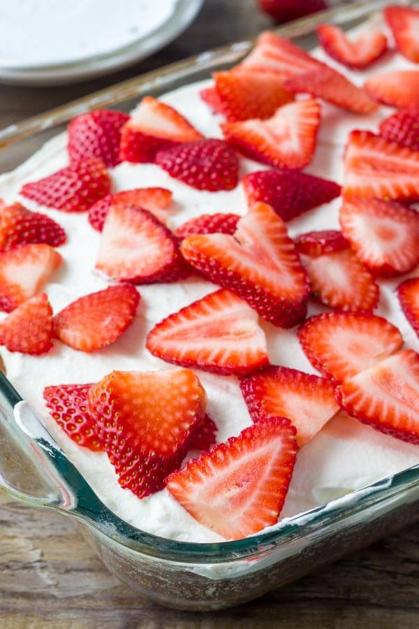Homemade strawberry cake - moist vanilla cake filled with berries and topped with whipped cream. 