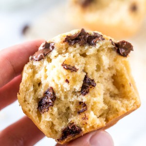 A moist banana bread muffin broken in half to show the fluffy texture.