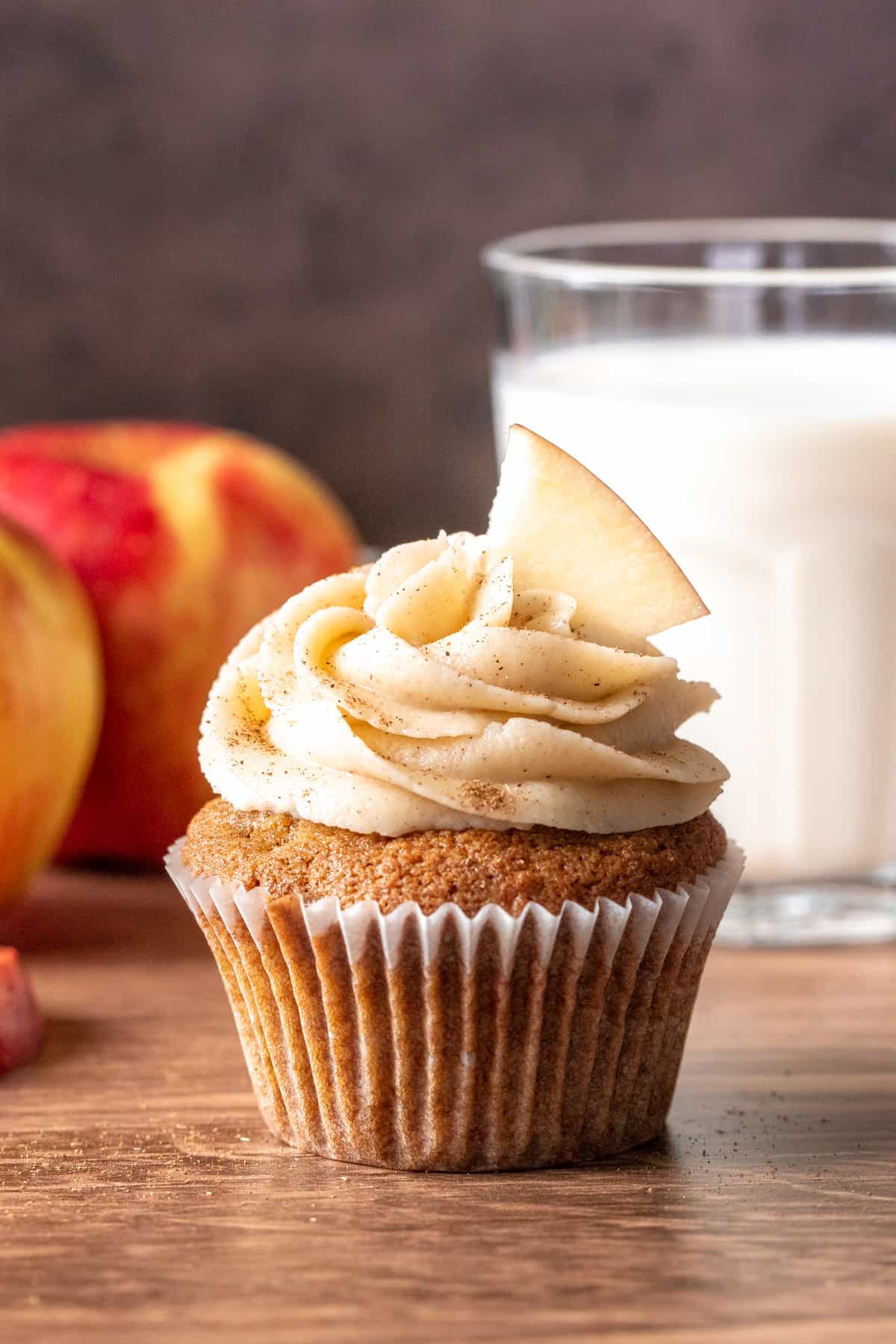 Apple cupcake with glass of milk and 2 apples