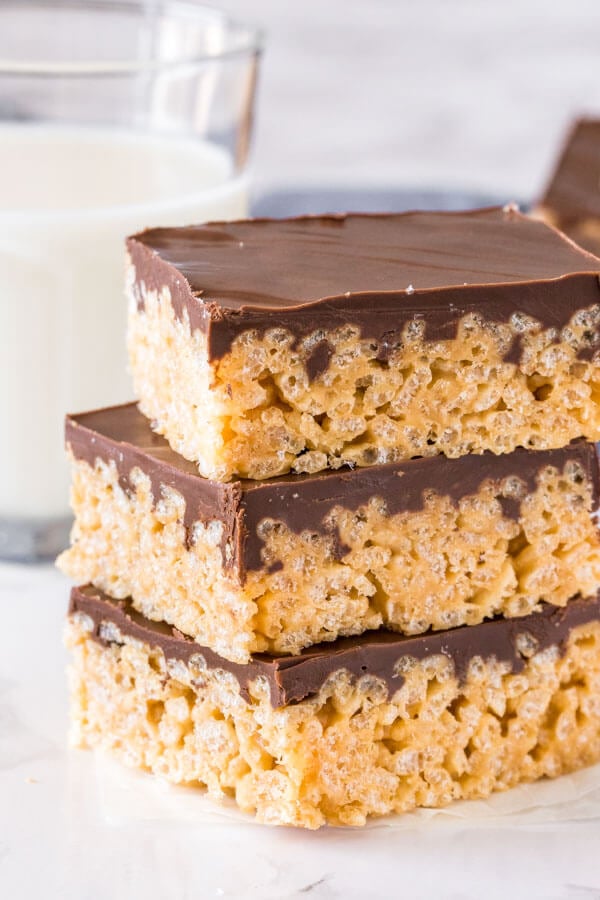 A stack of 3 peanut butter rice krispie treats with a layer of chocolate on top of each. 