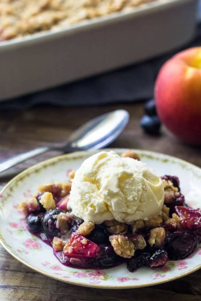 A serving of blueberry peach crumble with streusel topping makes for the perfect summer dessert. 
