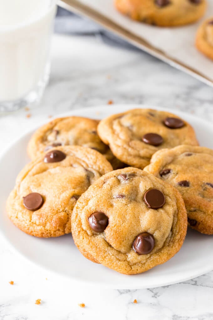 A plate of chewy chocolate chip pudding cookies with a glass of milk.