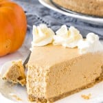 A slice of no-bake pumpkin cheesecake with a bite taken out of it to show the extra creamy texture.