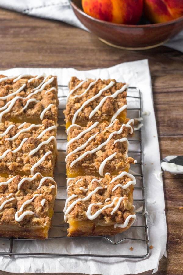 Peach Pie Bars with an oatmeal crumble topping & vanilla glaze. 
