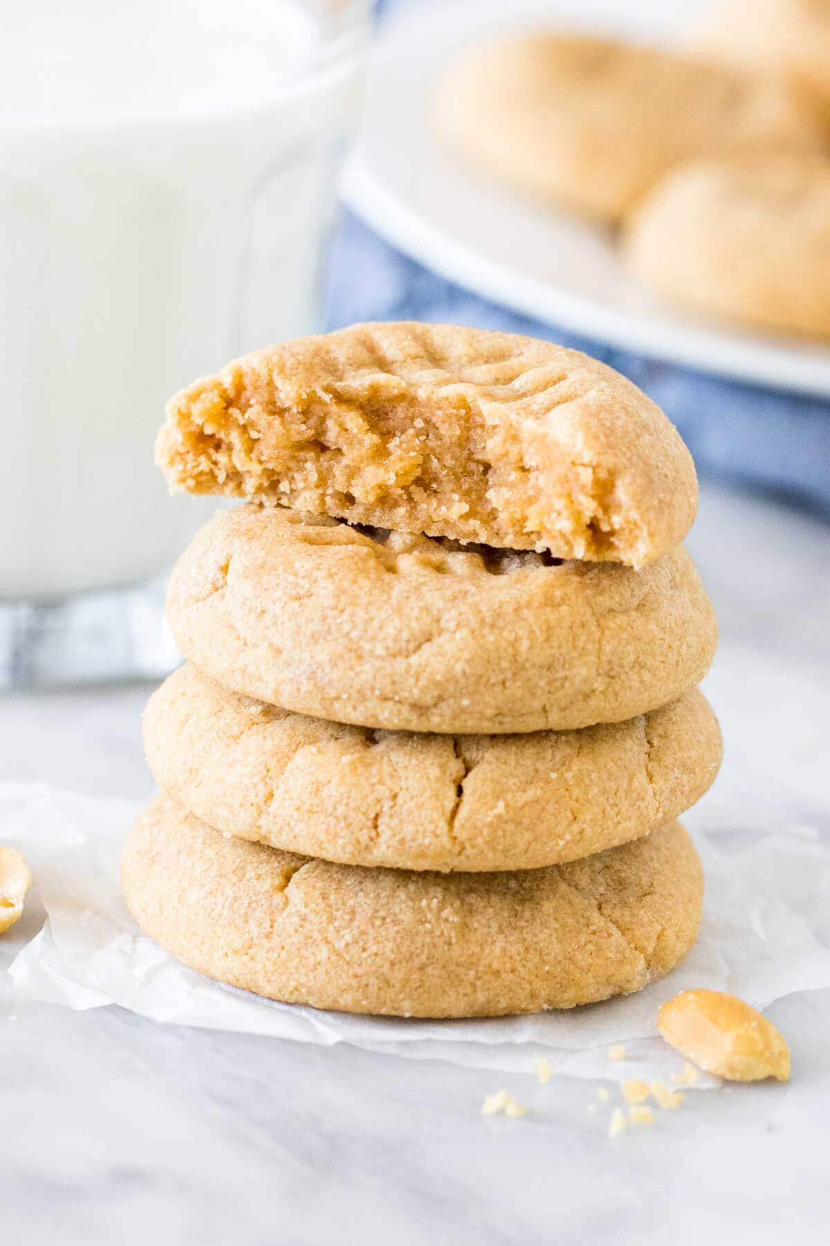 Stack of 4, three ingredient peanut butter cookies with the top cookie broken in half.