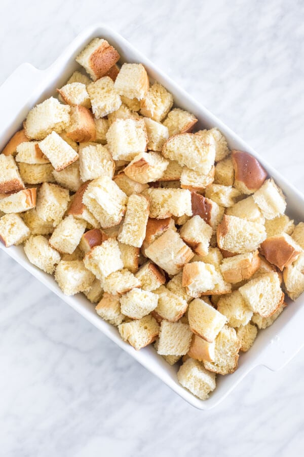 Casserole dish of bread cut into pieces to make French toast bake.
