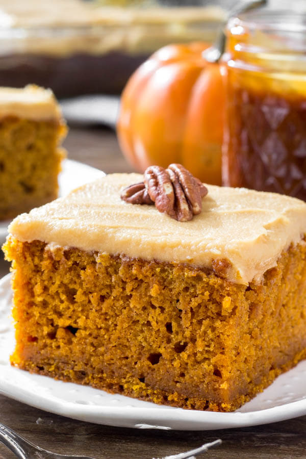 A slice of moist pumpkin cake with caramel cream cheese frosting is the perfect dessert for fall or Thanksgiving. 
